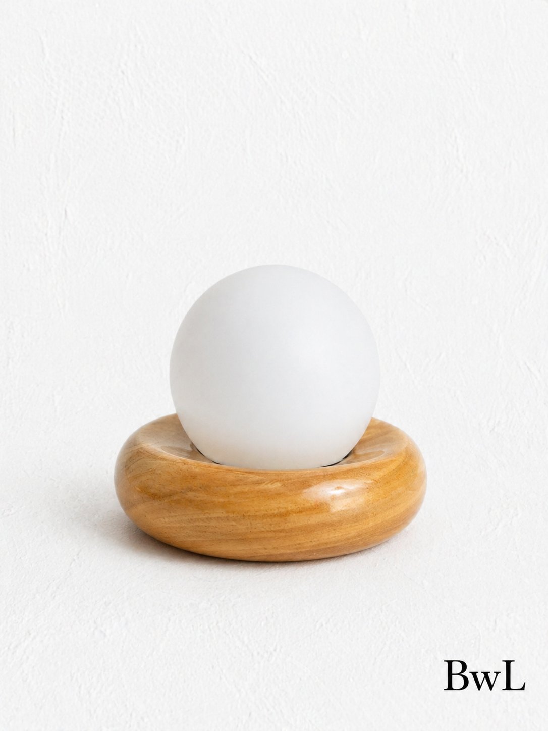 The Pearl — A frosted glass globe resting on a turned wooden ring.